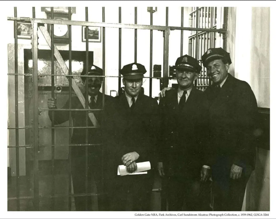 Historical black and white photograph of prison guards standing at the sallyport entrance of Alcatraz Federal Penitentiary between 1939 and 1962.