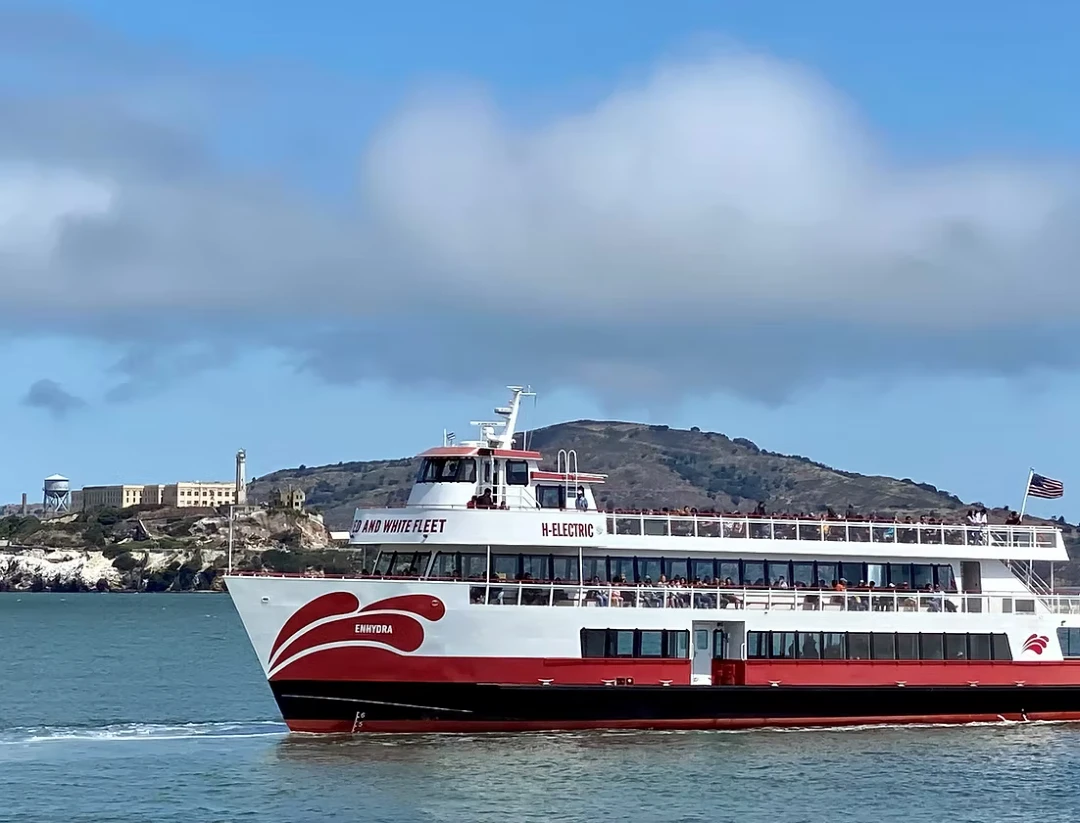 Red and White Fleet's Enhydra hybrid-electric boat sailing in front of Alcatraz Island.