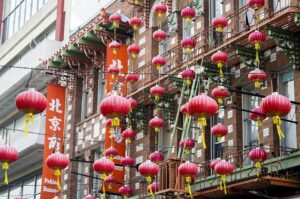 Vibrant red paper lanterns hanging across a street in San Francisco's Chinatown district.
