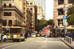 A classic San Francisco cable car passing through the busy Union Square shopping district.